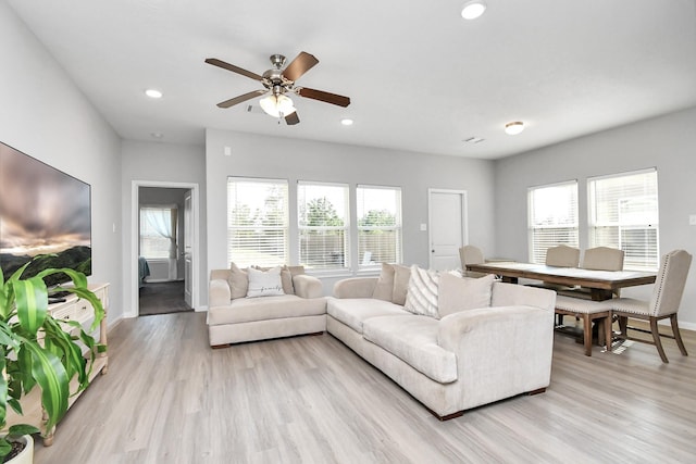 living area featuring light wood-type flooring, recessed lighting, baseboards, and a healthy amount of sunlight