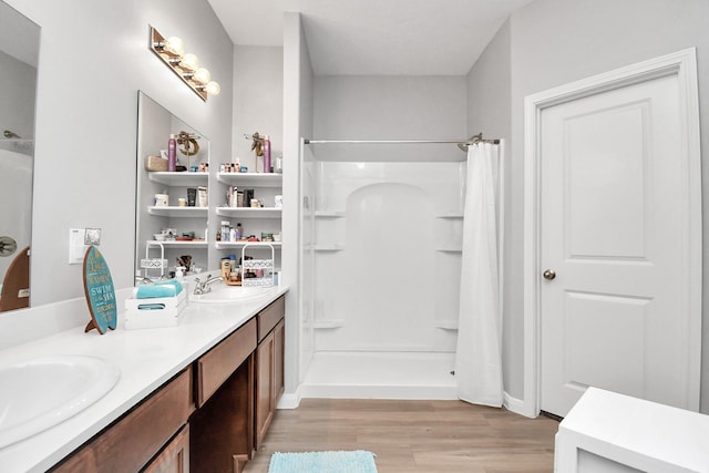 bathroom featuring a shower with curtain, a sink, and wood finished floors