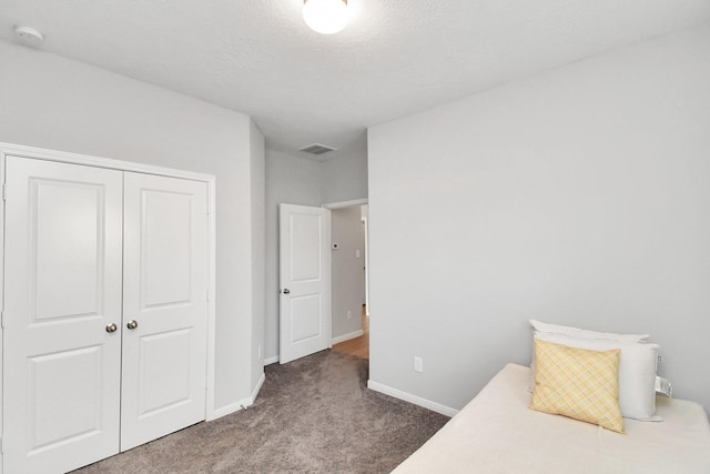 unfurnished bedroom with baseboards, visible vents, carpet, and a closet