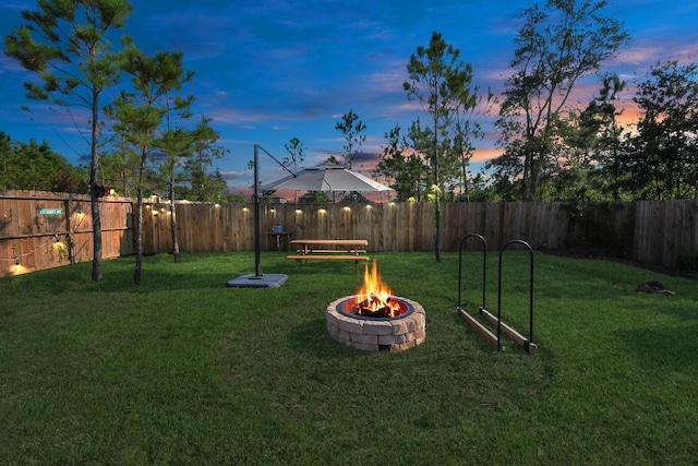 view of yard with a fire pit and a fenced backyard
