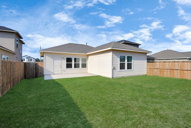 rear view of house featuring a lawn, a patio, and a fenced backyard
