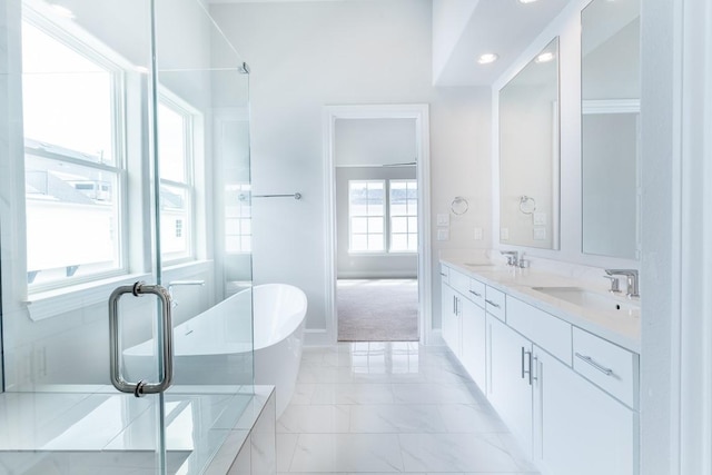 full bathroom featuring a freestanding tub, a sink, marble finish floor, and double vanity