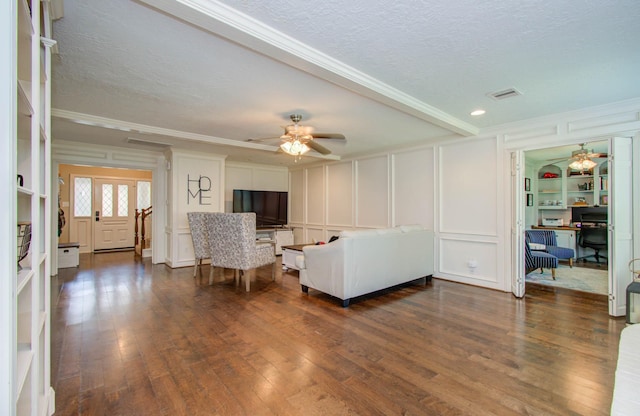 6711 Pebble Beach Dr, Houston, TX 77069 - living room with a decorative wall, ceiling fan, dark wood-style floors, crown molding, and a textured ceiling