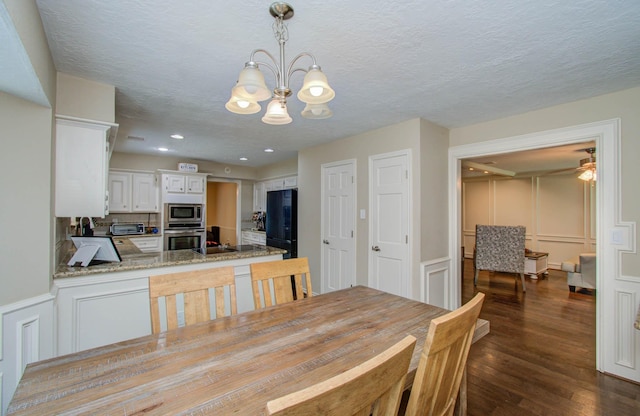 6711 Pebble Beach Dr, Houston, TX 77069 - dining area with a decorative wall, dark wood finished floors, a chandelier, wainscoting, and recessed lighting