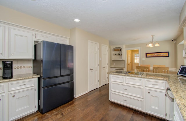 6711 Pebble Beach Dr, Houston, TX 77069 - kitchen featuring freestanding refrigerator, black electric cooktop, a chandelier, dark wood finished floors, and white cabinets