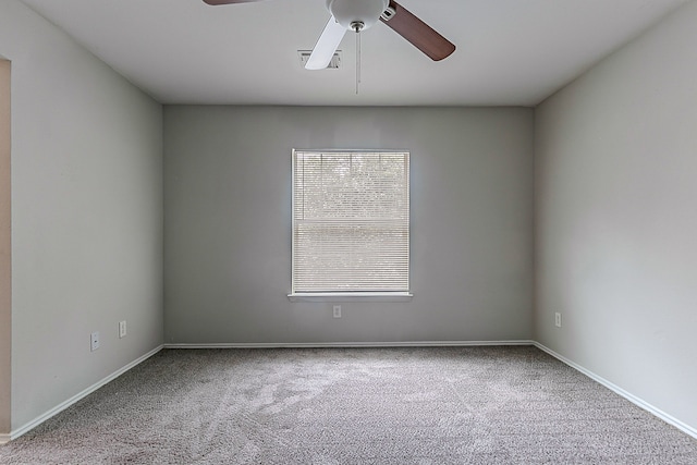 carpeted spare room with baseboards and a ceiling fan