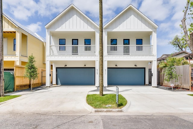 view of front of house with an attached garage, driveway, board and batten siding, and a balcony