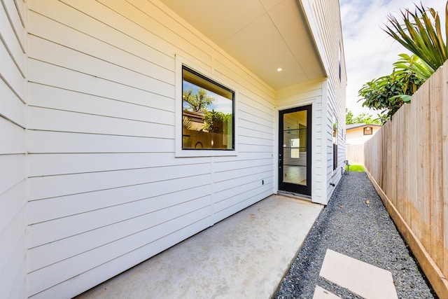 entrance to property featuring fence and a patio