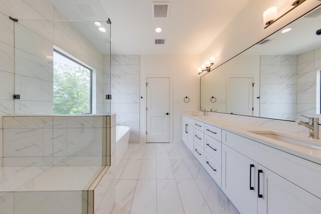 bathroom with a soaking tub, a sink, double vanity, visible vents, and marble finish floor