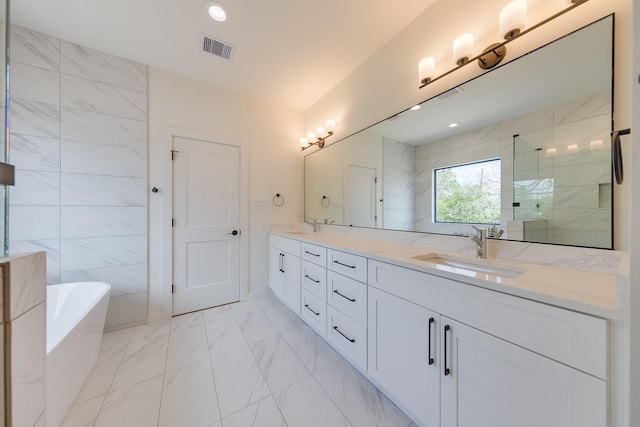 bathroom featuring marble finish floor, a freestanding bath, double vanity, visible vents, and a sink