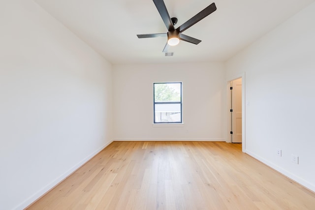 spare room with baseboards, a ceiling fan, visible vents, and light wood-style flooring