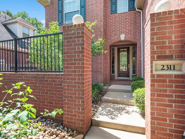 doorway to property featuring brick siding