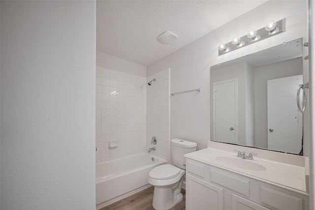bathroom with shower / washtub combination, wood finished floors, toilet, vanity, and a textured ceiling