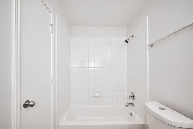bathroom featuring toilet, shower / bathtub combination, and a textured ceiling