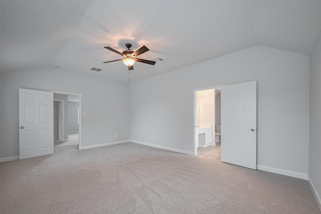 unfurnished bedroom with baseboards, lofted ceiling, visible vents, and light carpet