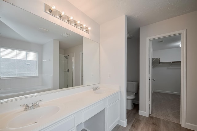 full bath featuring a shower stall, toilet, wood finished floors, and a sink