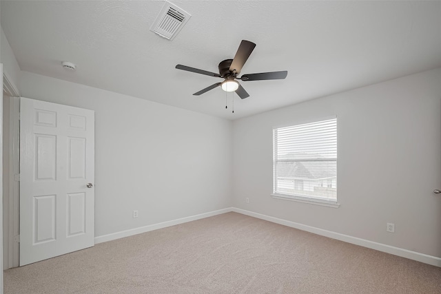 unfurnished room featuring visible vents, carpet flooring, baseboards, and ceiling fan