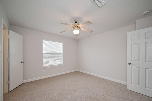 unfurnished bedroom with light colored carpet, baseboards, a ceiling fan, and visible vents