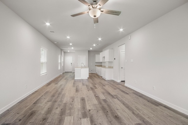 16899 Needlepoint Dr, Conroe, TX 77302 - unfurnished living room featuring light wood-type flooring, ceiling fan, and recessed lighting