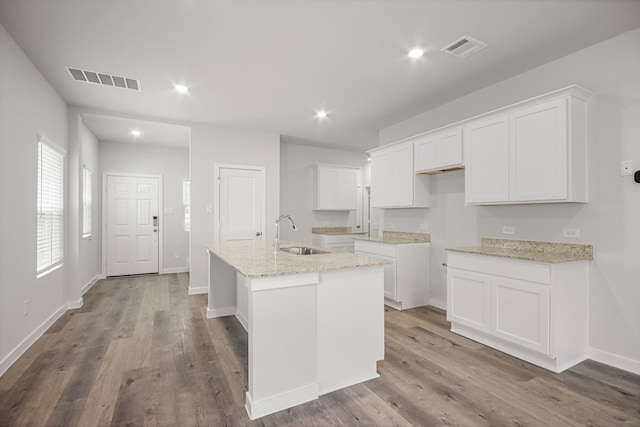 16899 Needlepoint Dr, Conroe, TX 77302 - kitchen with a center island with sink, white cabinetry, wood finished floors, and recessed lighting