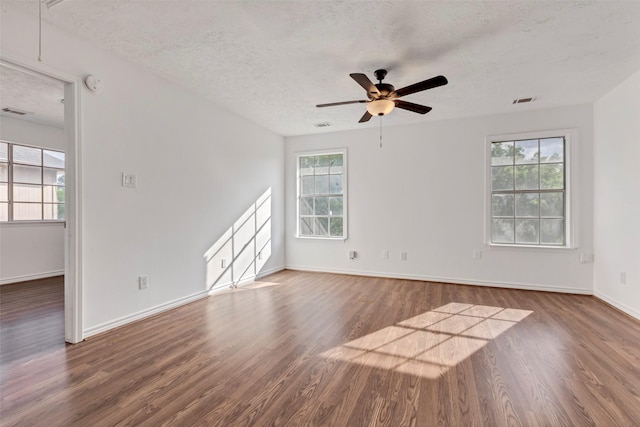 unfurnished room with wood finished floors, visible vents, baseboards, a textured ceiling, and ceiling fan