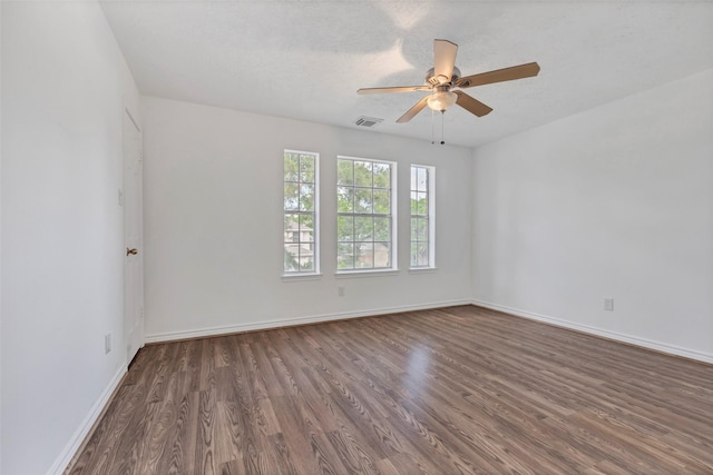spare room featuring ceiling fan, baseboards, wood finished floors, and visible vents