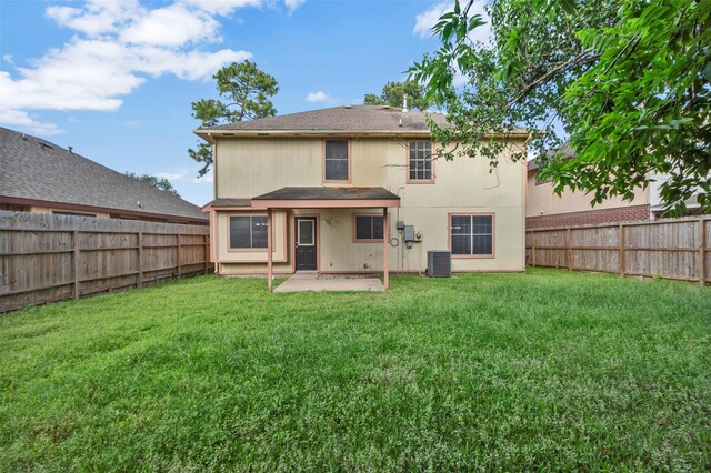 back of house featuring a fenced backyard, a yard, central AC, and a patio