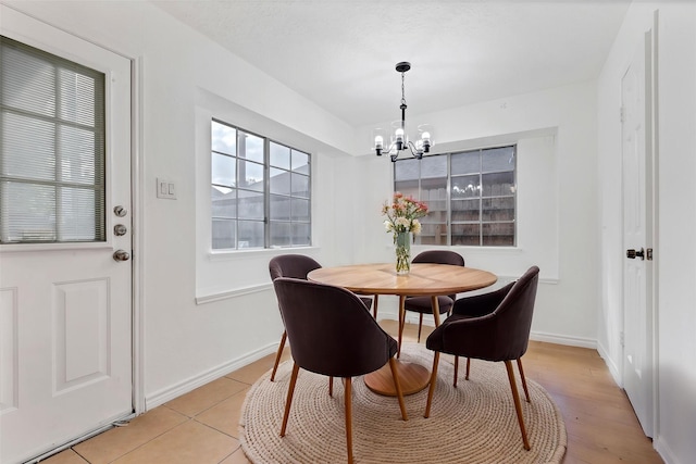 dining room with baseboards, a notable chandelier, and light tile patterned flooring