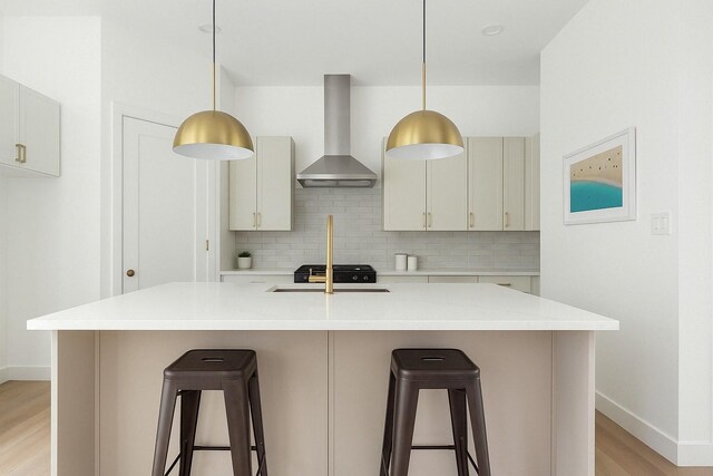 3824 Wilmer St, Houston, TX 77003 - kitchen featuring a breakfast bar area, light wood-type flooring, wall chimney exhaust hood, and decorative backsplash