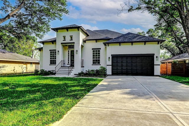 prairie-style house with stucco siding, a front lawn, driveway, and a garage