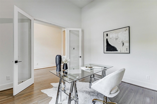 office area featuring wood finished floors, baseboards, and french doors