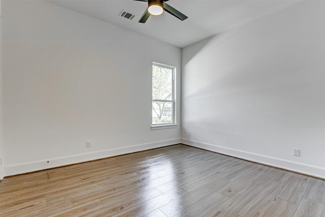 empty room with lofted ceiling, visible vents, a ceiling fan, light wood-type flooring, and baseboards