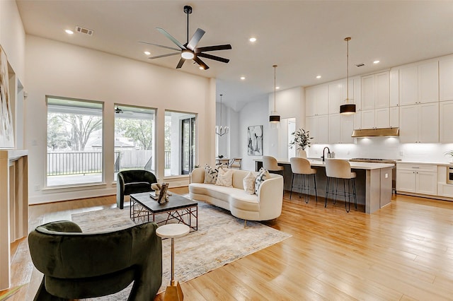 living area featuring ceiling fan, recessed lighting, visible vents, and light wood-style flooring