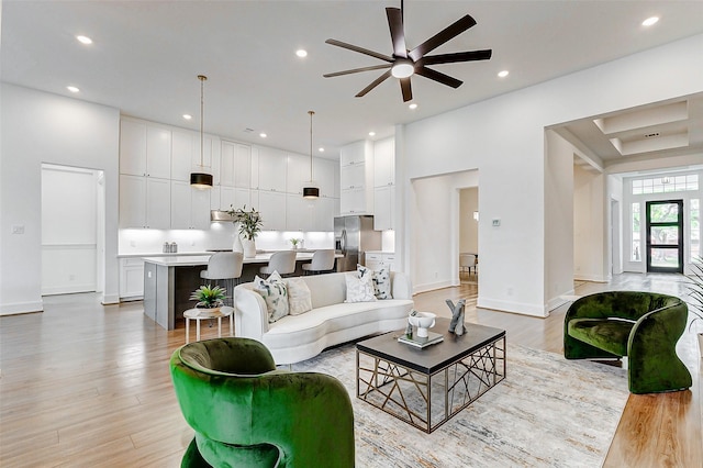 living area with recessed lighting, light wood-type flooring, baseboards, and ceiling fan