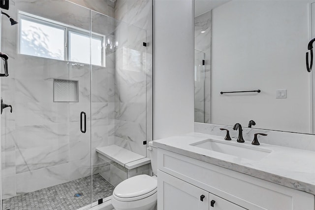 full bathroom featuring toilet, vanity, and a marble finish shower