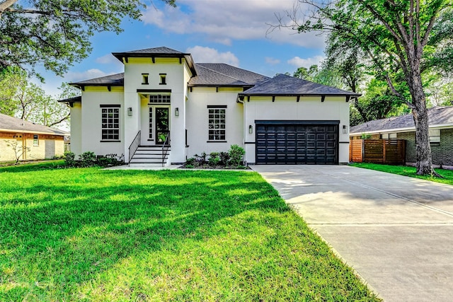 prairie-style house with concrete driveway, fence, a garage, a front yard, and stucco siding