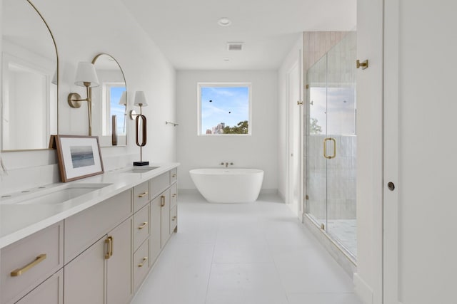 3826 Wilmer St, Houston, TX 77003 - bathroom with double vanity, visible vents, a freestanding tub, a shower stall, and a sink