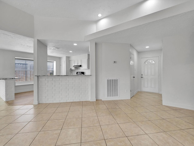 403 Elder Vista Dr, Houston, TX 77598 - unfurnished living room with baseboards, a textured ceiling, visible vents, and light tile patterned floors