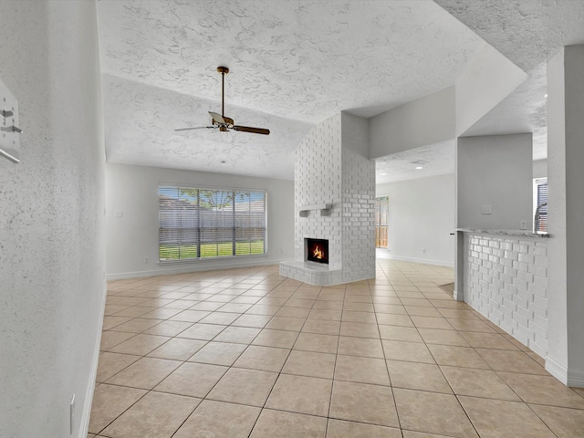 403 Elder Vista Dr, Houston, TX 77598 - unfurnished living room featuring light tile patterned flooring, a textured ceiling, a ceiling fan, and a fireplace