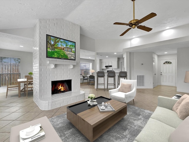 403 Elder Vista Dr, Houston, TX 77598 - living room with vaulted ceiling, visible vents, a ceiling fan, a brick fireplace, and light tile patterned floors