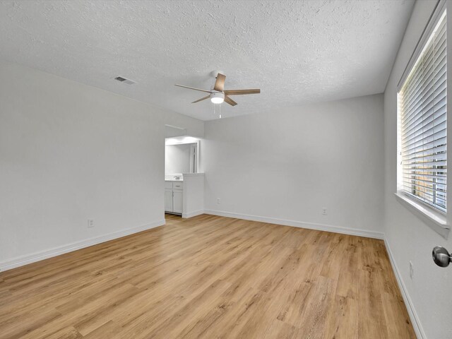 403 Elder Vista Dr, Houston, TX 77598 - empty room featuring a textured ceiling, ceiling fan, light wood-style flooring, baseboards, and visible vents