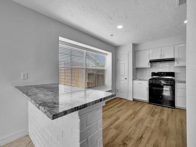 403 Elder Vista Dr, Houston, TX 77598 - kitchen with black range with gas cooktop, under cabinet range hood, a textured ceiling, and white cabinetry