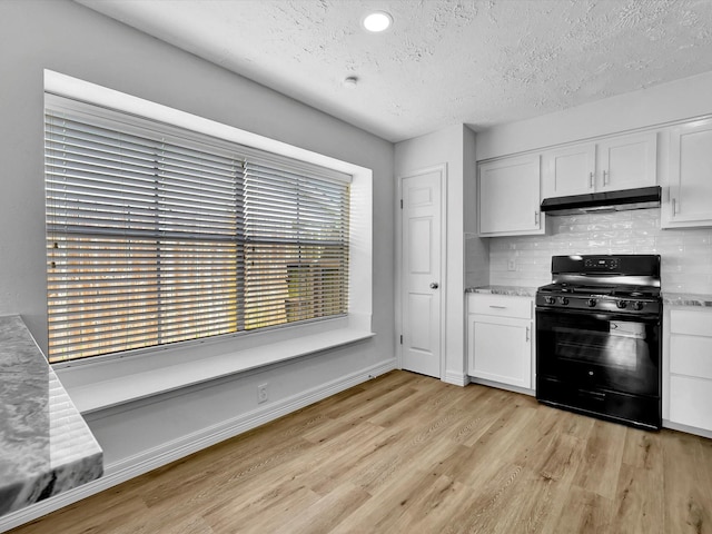 403 Elder Vista Dr, Houston, TX 77598 - kitchen with black gas range oven, under cabinet range hood, light wood-style flooring, a textured ceiling, and white cabinetry