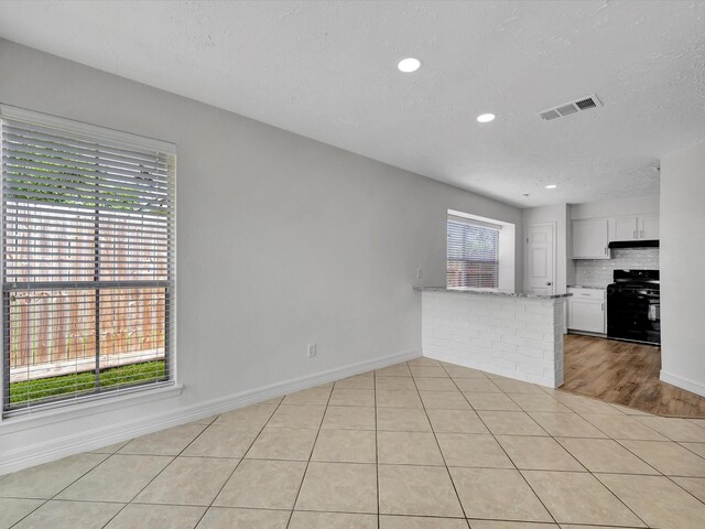 403 Elder Vista Dr, Houston, TX 77598 - unfurnished living room with a textured ceiling, visible vents, baseboards, and light tile patterned floors