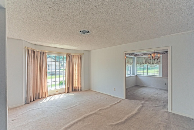 1345 10th St, Hempstead, TX 77445 - unfurnished room with a textured ceiling, visible vents, carpet floors, and a notable chandelier
