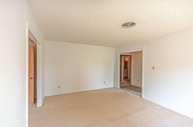 1345 10th St, Hempstead, TX 77445 - empty room featuring light colored carpet, a textured ceiling, and visible vents