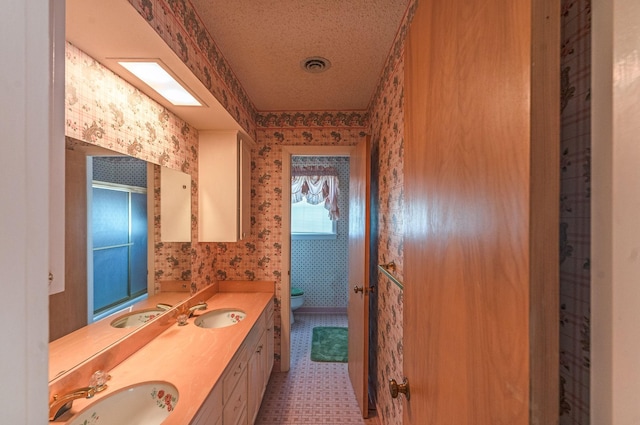 1345 10th St, Hempstead, TX 77445 - bathroom featuring wallpapered walls, a sink, and toilet