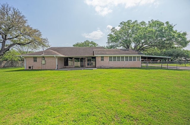 1345 10th St, Hempstead, TX 77445 - rear view of property with brick siding, fence, a yard, and an attached carport