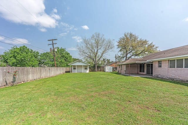 1345 10th St, Hempstead, TX 77445 - view of yard featuring a fenced backyard, an outdoor structure, a patio area, and a shed