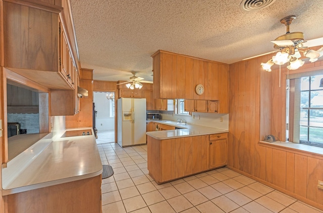 1345 10th St, Hempstead, TX 77445 - kitchen with a ceiling fan, a sink, white refrigerator with ice dispenser, light countertops, and a peninsula